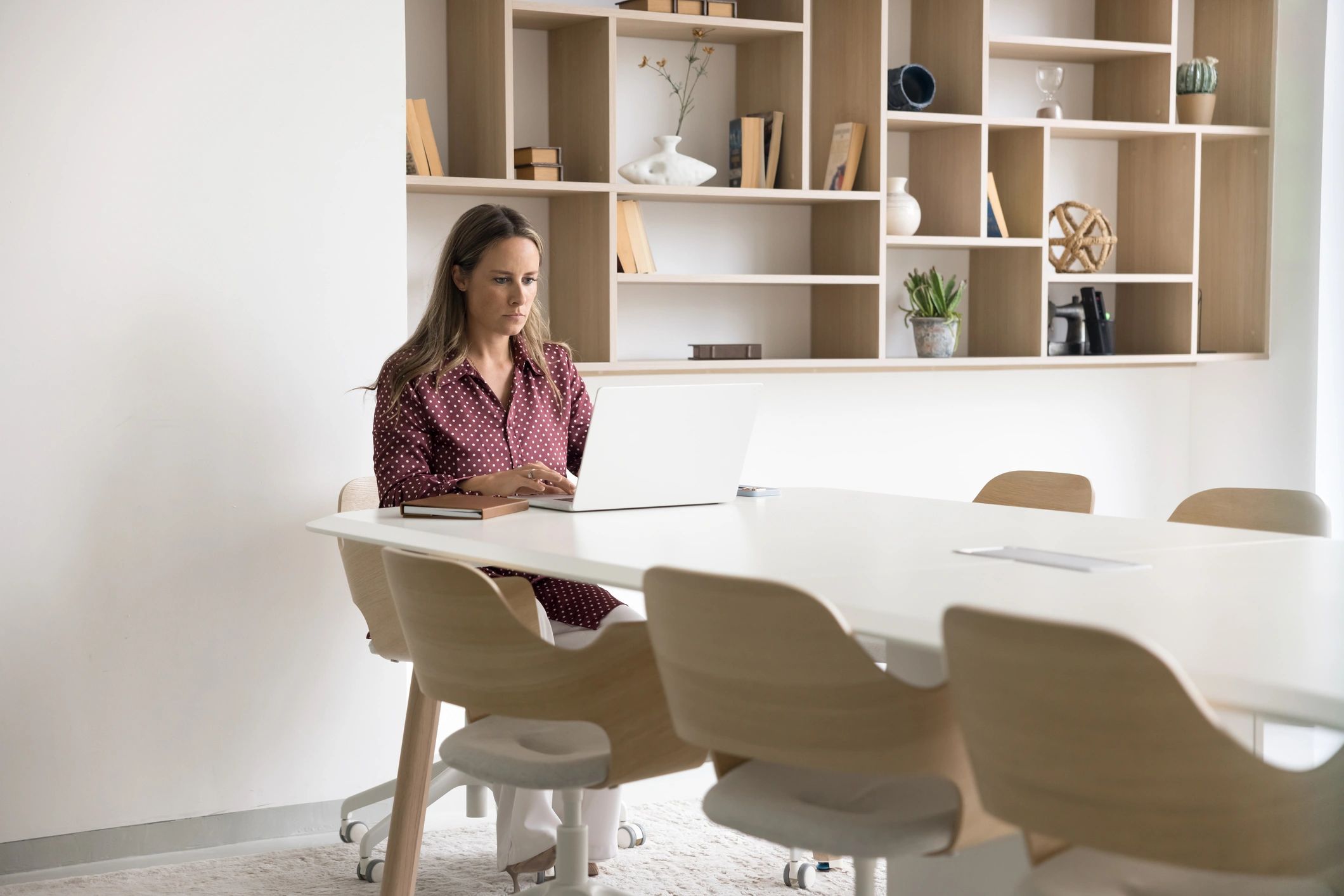 Web designer working on a laptop in a bright office